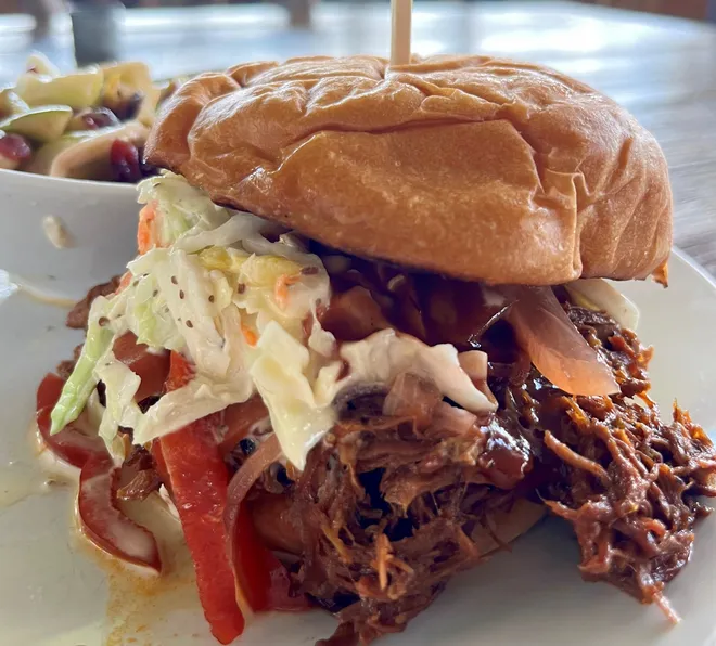 We love Blossom & Brie's pulled pork sandwich with pulled and smoked red wattle pork, sweet heat barbecue sauce, homemade coleslaw and pickled vegetables.