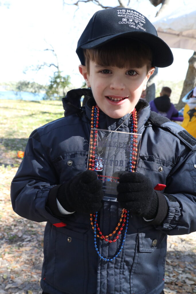 Child holding team award. 