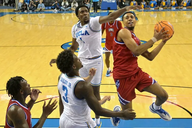 Nov 10, 2025; Los Angeles, California, USA; West Georgia Wolves guard Josh Smith (10) drives past UCLA Bruins center Xavier Booker (1) during the first half at Pauley Pavilion presented by Wescom Financial.