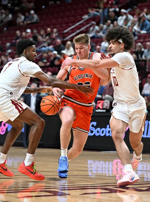 Feb 10, 2026; Tallahassee, Florida, USA; Virginia Cavaliers forward Thijs De Ridder (28) loses the ball as he is defended by Florida State Seminoles forward Chauncey Wiggins (7) and guard Lajae Jones (10) during the first half at Donald L. Tucker Center. Mandatory Credit: Melina Myers-Imagn Images