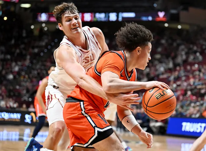 Feb 10, 2026; Tallahassee, Florida, USA; Virginia Cavaliers guard Sam Lewis (5) moves the ball away from Florida State Seminoles forward Alex Steen (25) during the first half at Donald L. Tucker Center. Mandatory Credit: Melina Myers-Imagn Images