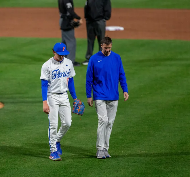 Florida's pitcher Russell Sandefer (17) walks off the field with Athletic Trainer Jarrett Schweim, Friday, February 13, 2026, at Condron Family Ballpark in Gainesville, Florida. The Gators lost Game 1 to the Blazers 9-7. [Cyndi Chambers/ Gainesville Sun] 2026