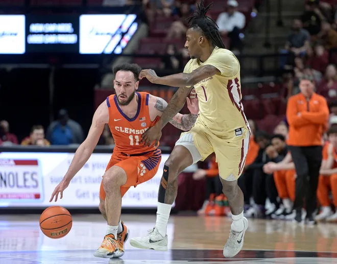 Feb 15, 2025; Tallahassee, Florida, USA; Clemson Tigers guard Jaeden Zackery (11) drives the ball around Florida State Seminoles forward Jamir Watkins (1) during the first half at Donald L. Tucker Center. Mandatory Credit: Melina Myers-Imagn Images