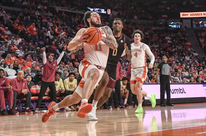Jan 11, 2025; Clemson, South Carolina, USA; Clemson Tigers guard Jaeden Zachery (11) drives to score against Florida State Seminoles guard Chandler Jackson (0) during the first half at Littlejohn Coliseum. Mandatory Credit: Ken Ruinard/USA TODAY Network via Imagn Images