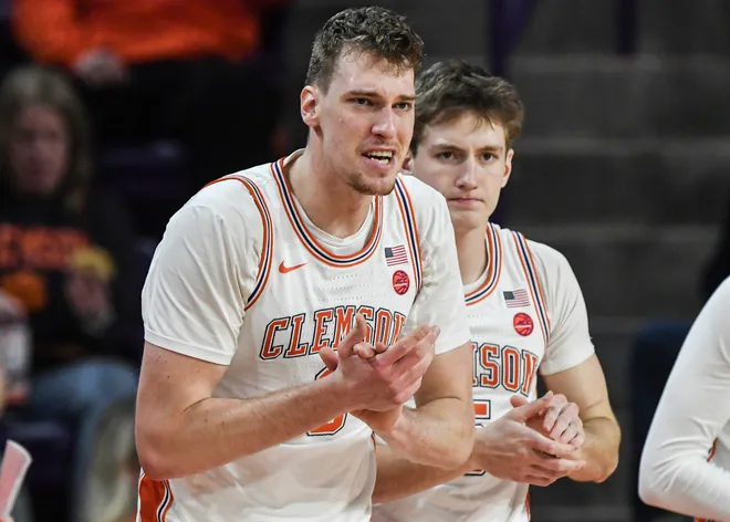 Jan 11, 2025; Clemson, South Carolina, USA; Clemson Tigers center Viktor Lakhin (0) and forward Asa Thomas (5) claps from the bench during the first half against the Florida State Seminoles at Littlejohn Coliseum. Mandatory Credit: Ken Ruinard/USA TODAY Network via Imagn Images