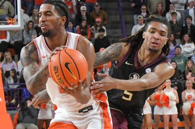 Jan 11, 2025; Clemson, South Carolina, USA; Clemson Tigers guard Dillon Hunter (2) scores against Florida State Seminoles guard Daquan Davis (5) during the second half at Littlejohn Coliseum. Mandatory Credit: Ken Ruinard/USA TODAY Network via Imagn Images