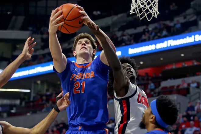 Feb 21, 2026; Oxford, Mississippi, USA; Florida Gators forward/center Alex Condon (21) collects a rebound over Mississippi Rebels forward Corey Chest (1) during the first half at The Sandy and John Black Pavilion at Ole Miss. Mandatory Credit: Petre Thomas-Imagn Images