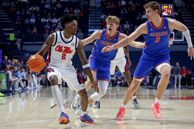 Feb 21, 2026; Oxford, Mississippi, USA; Mississippi Rebels guard AJ Storr (2) dribbles as Florida Gators forward Thomas Haugh (10) and center Micah Handlogten (3) defend during the first half at The Sandy and John Black Pavilion at Ole Miss. Mandatory Credit: Petre Thomas-Imagn Images