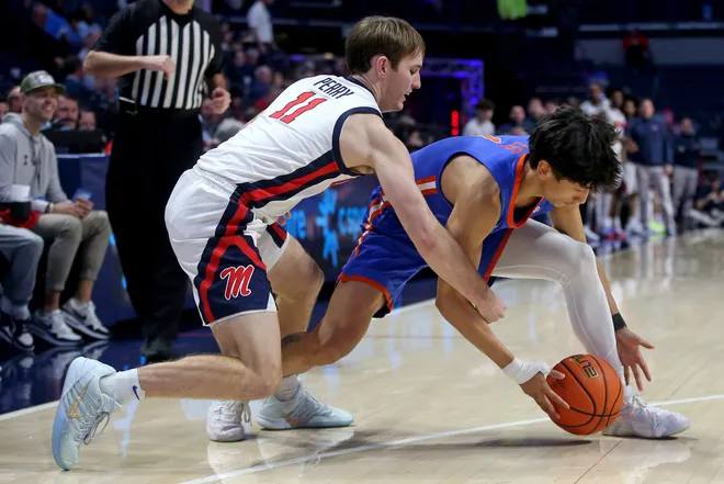 Feb 21, 2026; Oxford, Mississippi, USA; Mississippi Rebels guard Travis Perry (11) and Florida Gators guard Xaivian Lee (1) battle for a loose ball during the second half at The Sandy and John Black Pavilion at Ole Miss. Mandatory Credit: Petre Thomas-Imagn Images