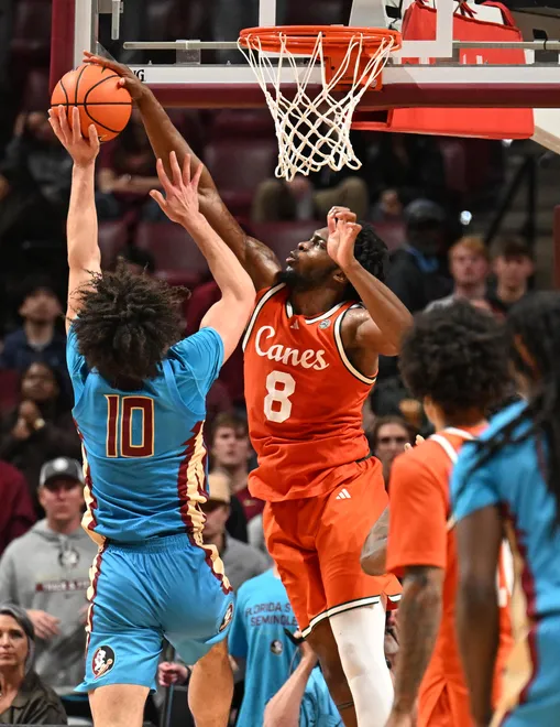 Feb 24, 2026; Tallahassee, Florida, USA; Miami Hurricanes center Ernest Udeh Jr. (8) blocks a shot by Florida State Seminoles guard Lajae Jones (10) during the second half at Donald L. Tucker Center. Mandatory Credit: Melina Myers-Imagn Images