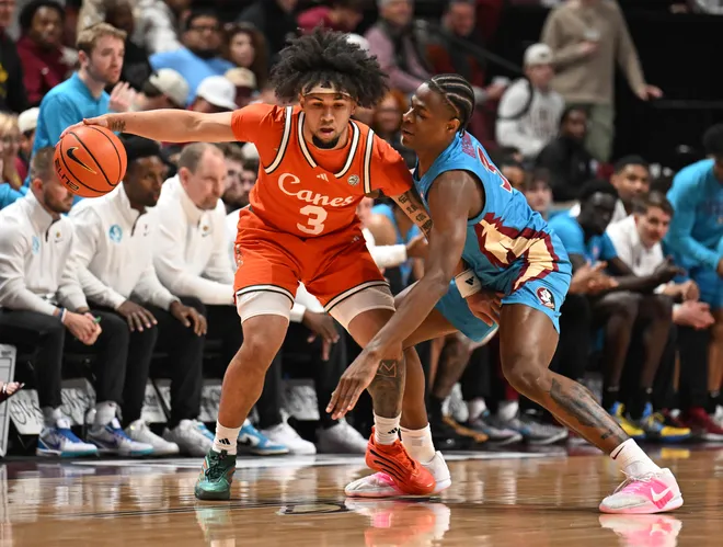 Feb 24, 2026; Tallahassee, Florida, USA; Miami Hurricanes guard Tre Donaldson (3) dribbles the ball as Florida State Seminoles forward Thomas Bassong (3) defends during the first half at Donald L. Tucker Center. Mandatory Credit: Melina Myers-Imagn Images