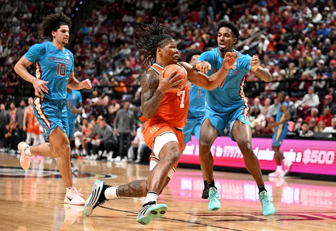 Feb 24, 2026; Tallahassee, Florida, USA; Miami Hurricanes forward Shelton Henderson (7) drives to the net past Florida State Seminoles forward Chauncey Wiggins (7) during the first half at Donald L. Tucker Center. Mandatory Credit: Melina Myers-Imagn Images