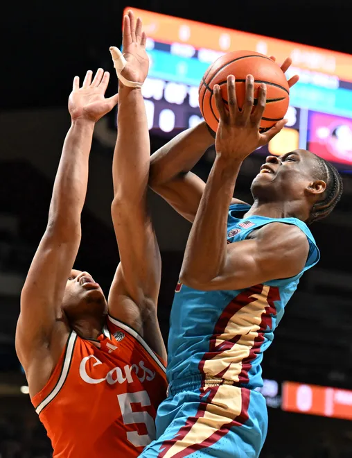 Feb 24, 2026; Tallahassee, Florida, USA; Miami Hurricanes forward Malik Reneau (5) attempts to block a shot from Florida State Seminoles forward Thomas Bassong (3) during the first half at Donald L. Tucker Center. Mandatory Credit: Melina Myers-Imagn Images