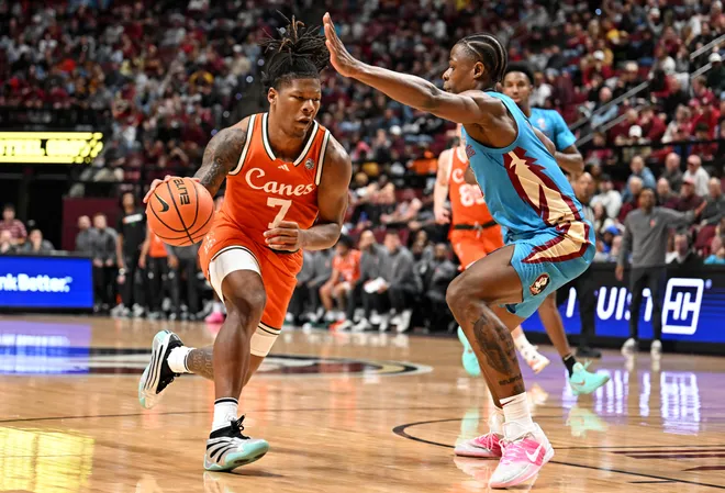 Feb 24, 2026; Tallahassee, Florida, USA; Miami Hurricanes forward Shelton Henderson (7) drives to the net past Florida State Seminoles forward Thomas Bassong (3) during the first half at Donald L. Tucker Center. Mandatory Credit: Melina Myers-Imagn Images