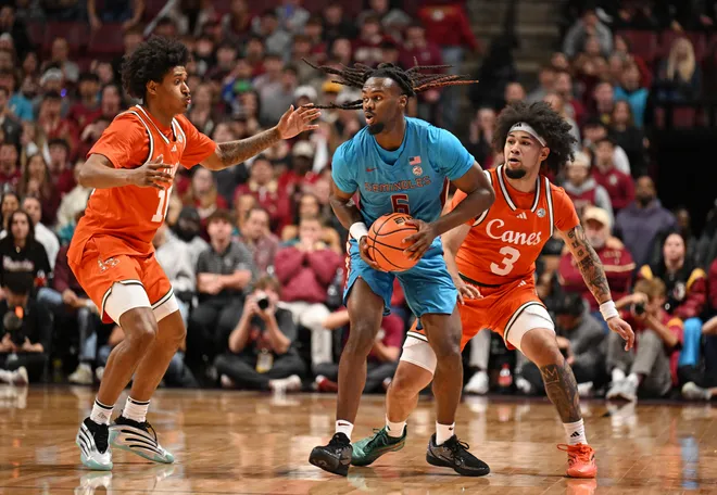 Feb 24, 2026; Tallahassee, Florida, USA; Miami Hurricanes guard Tru Washington (10) and guard Tre Donaldson (3) defend Florida State Seminoles guard Robert McCray (6) during the second half at Donald L. Tucker Center. Mandatory Credit: Melina Myers-Imagn Images