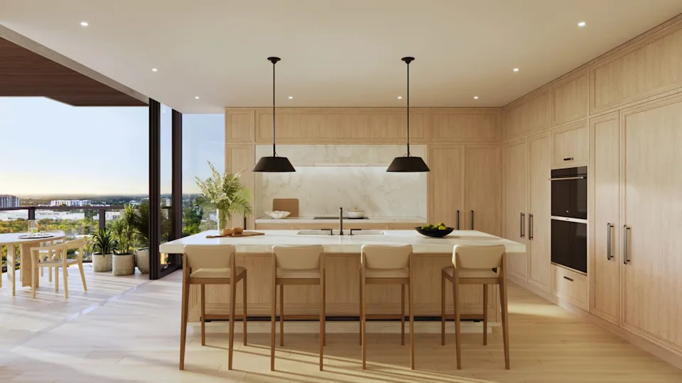 A kitchen with counter seating leading to a balcony in The Ritz-Carlton waterfront residences in South Florida