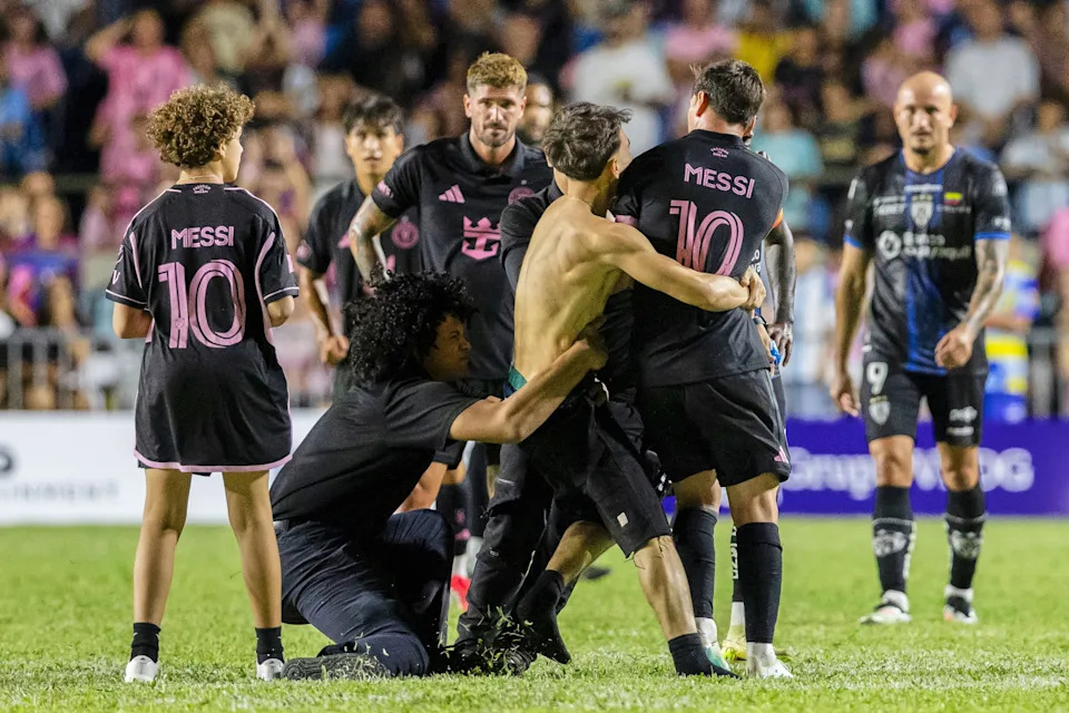 A fan who got onto the field grabs Inter Miami's Lionel Messi at the end of an international friendly soccer match against Ecuador's Independiente del Valle in Bayamon, Puerto Rico, Thursday, Feb. 26, 2026. (AP Photo/Alejandro Granadillo)