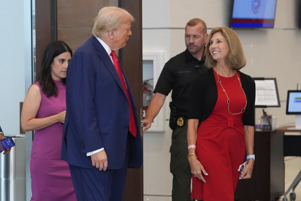President Donald Trump talks with Palm Beach County Supervisor of Elections Wendy Sartory Link as he voted early in the Florida primary on Aug. 14, 2024, in West Palm Beach. He used the ExpressVote system without objection or incident. (Wilfredo Lee/Associated Press)