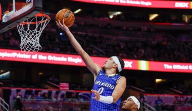 Orlando Magic guard Anthony Black (0) lays up the ball over Milwaukee Bucks center Myles Turner, center right, during the second half of an NBA basketball game Monday, Feb. 9, 2026, in Orlando, Fla. (AP Photo/Kevin Kolczynski)