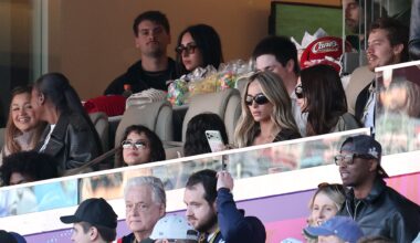 photo of people in a box in the stands at a football game