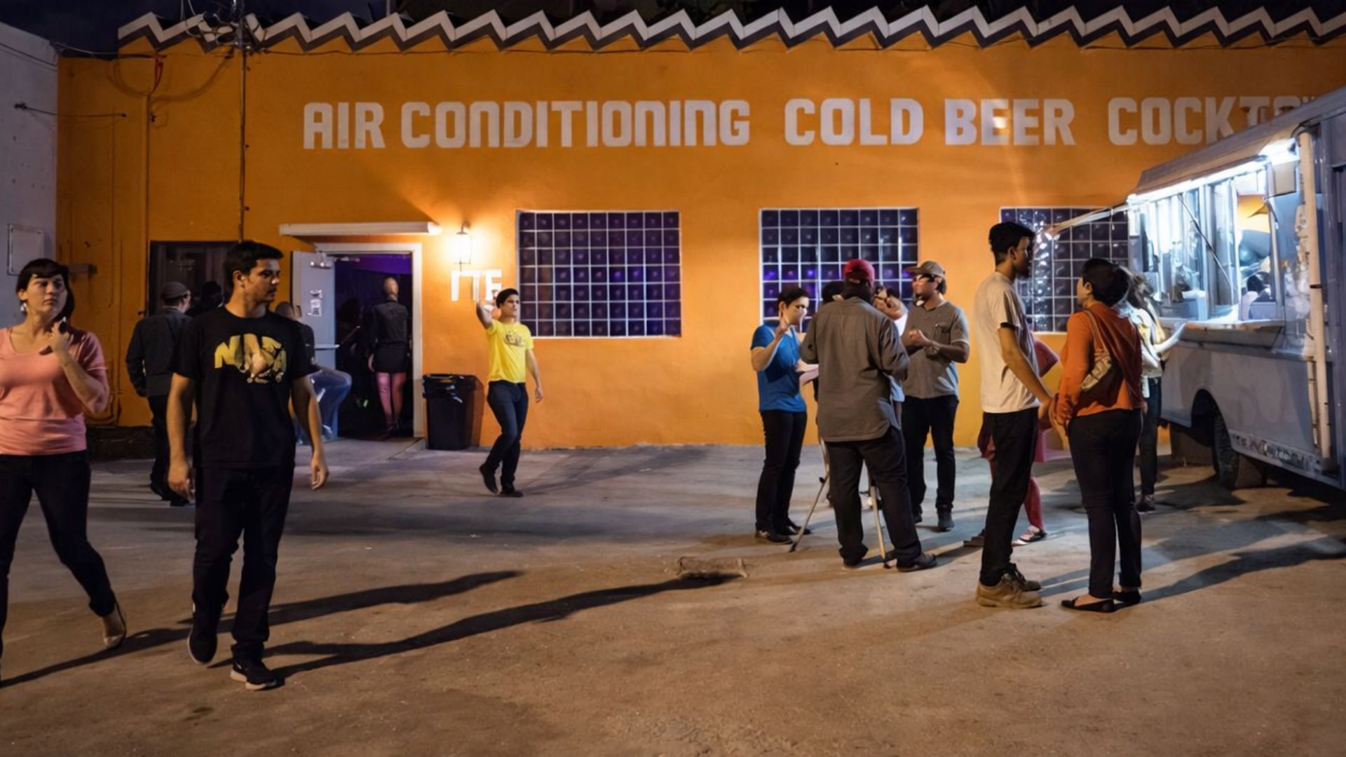 Outside of a property that reads Air conditioning , Cold beer