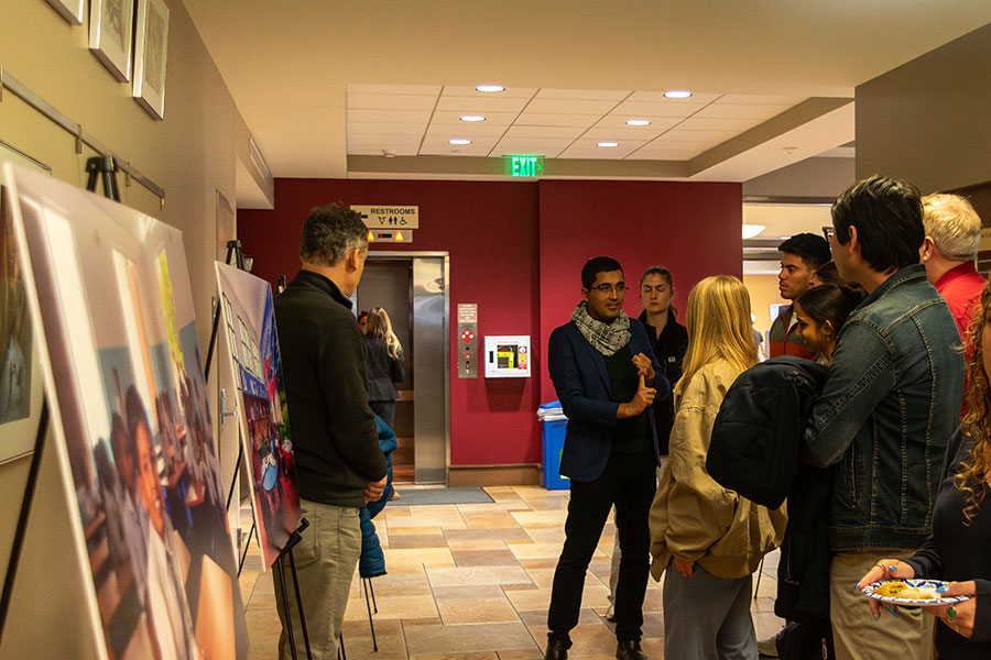 Bhushan Dahal, a doctoral candidate in Anne's College, talks to attendees about the photo exhibit and book launch highlighting the work of Kids of Kathmandu, a nonprofit organization that build schools in Nepal. (Jalisa Redding/Center for Global Engagement)
