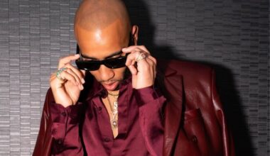 Photo of a bald man wearing a red leather suit and sunglasses