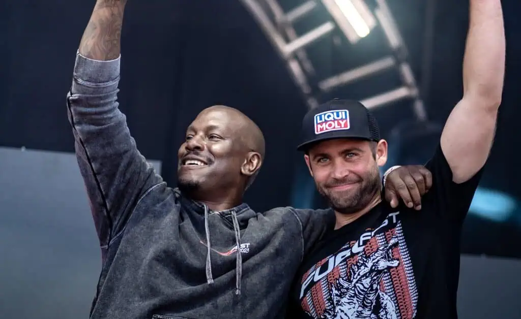 two men on stage holding up microphones