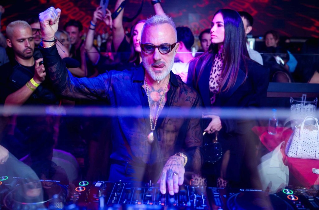 photo of Gianluca Vacchi DJing at a club in a black mesh shirt