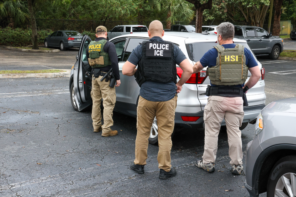 Immigration officers standing next to a car