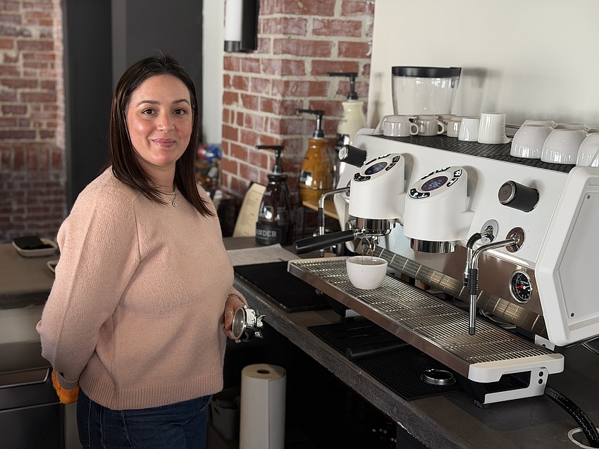 Cafe San Marco and Bar San Marco owner Daimi Morales shows off the $13,000 coffee maker the restaurant bought.