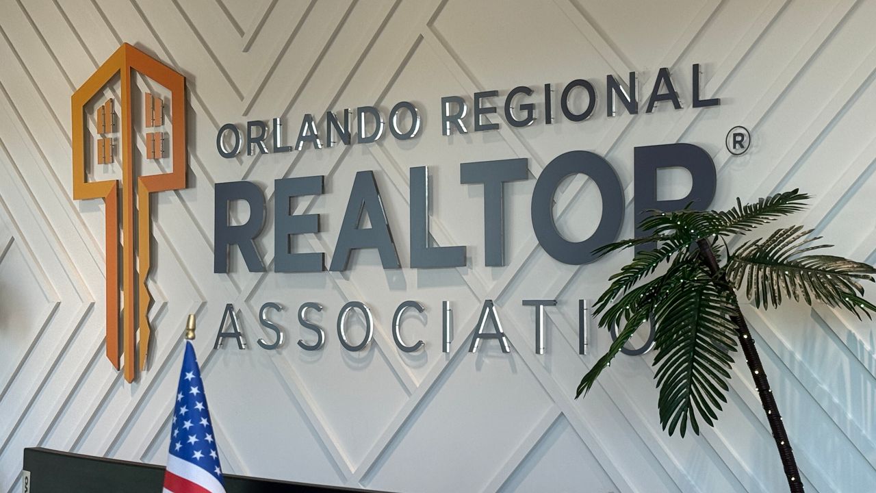 Black lettering and an orange key are shown on the Orlando Regional Realtor Association sign at the office's front desk.