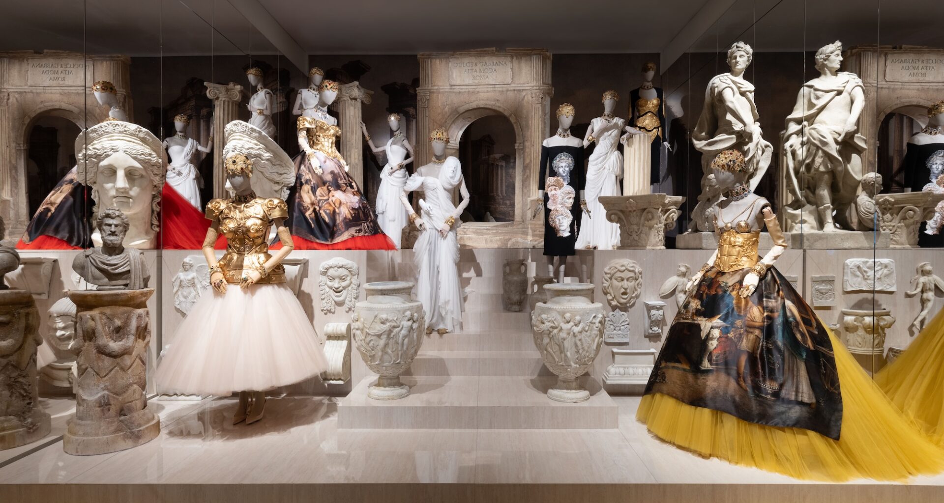 photo of ornate dresses on mannequins on a platform inside an art gallery