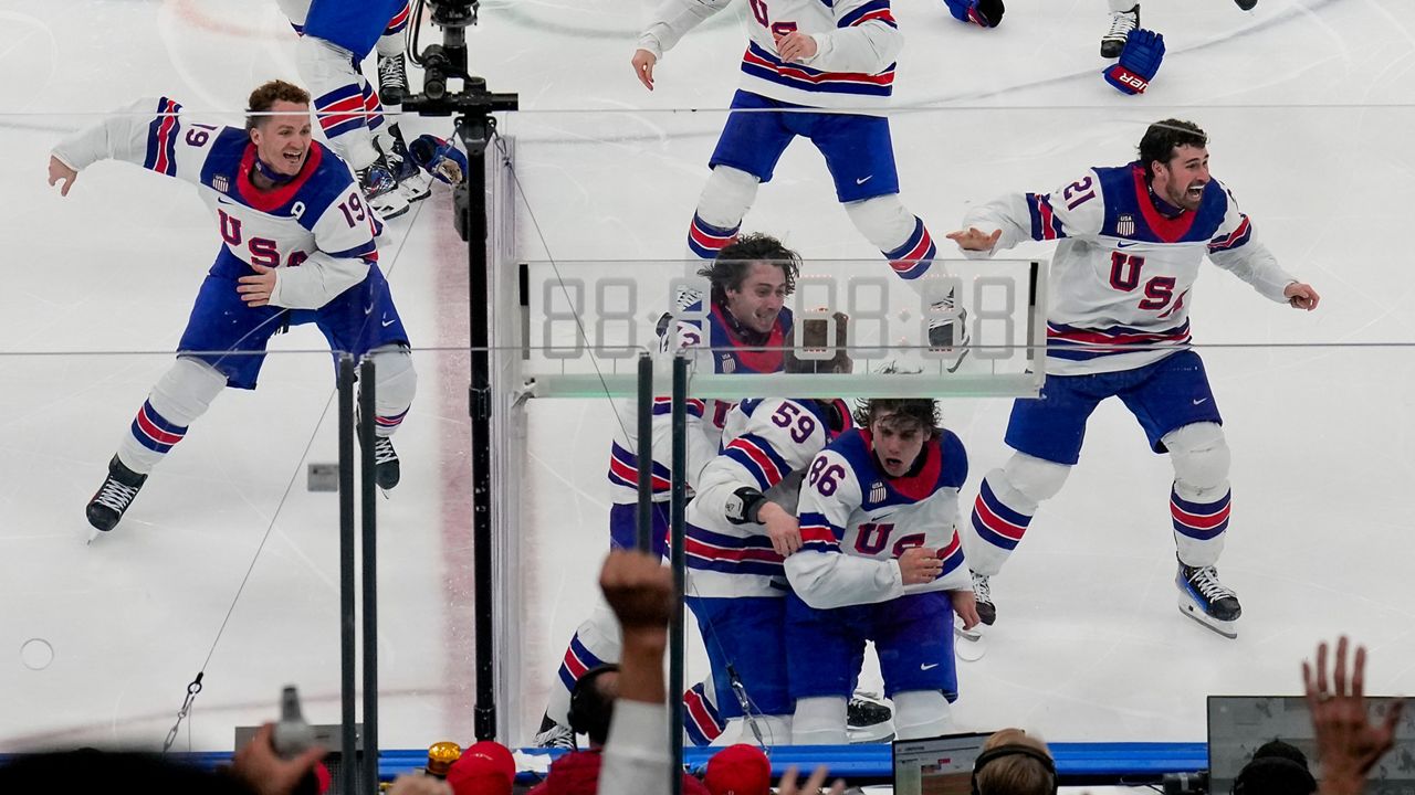 The United States celebrates after a sudden-death overtime goal by United States' Jack Hughes (86) against Canada during the men's ice hockey gold medal game at the 2026 Winter Olympics, in Milan, Italy, Sunday, Feb. 22, 2026. (AP Photo/Luca Bruno)