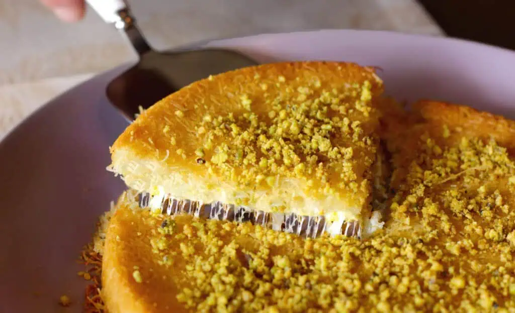 a cheese layered dessert topped with pistachio 