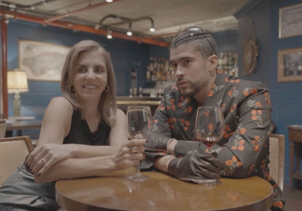 Photo of two people sitting at a table drinking wine. 