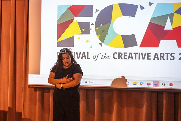 A woman presents in front of a screen reading "FCA Festival of the Creative Arts 2026"