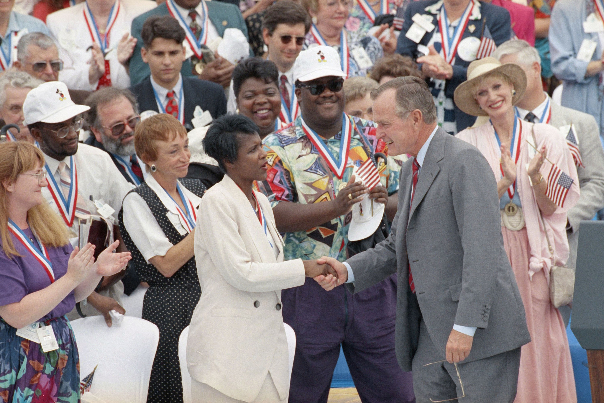 U.S. President George H. Bush, right, shakes hands with some...