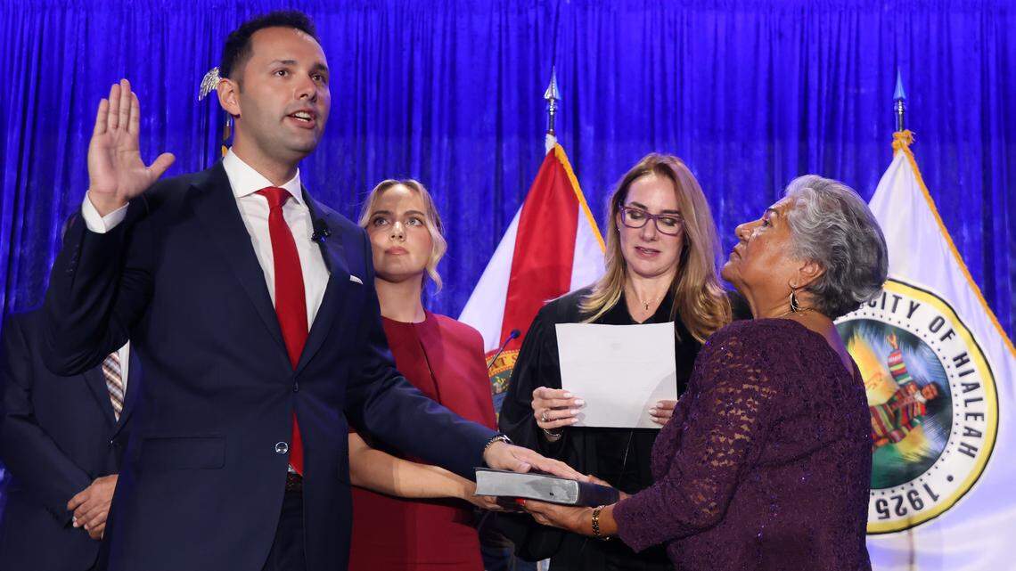 Bryan Calvo, 28, standing with his girlfriend, Melianni Terrero, Hialeah, and his mother, Edith Calvo, far right, is sworn in as mayor of Hialeah by Miami-Dade Circuit Judge Carmen Cabarga at the Milander Center on Monday, Jan. 12, 2026, in Hialeah.