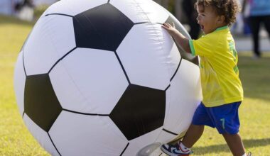 Brazilian fan Noah Silva Castro, 1, kicks an inflatable soccer ball during the FIFA World Cup 2026 Final Draw watch party at the Amphitheater Doral Central Park on Friday, Dec. 5, 2025, in Doral, Fla.