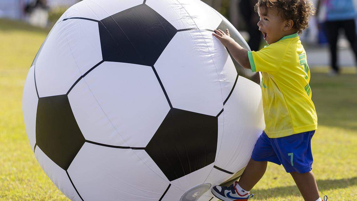 Brazilian fan Noah Silva Castro, 1, kicks an inflatable soccer ball during the FIFA World Cup 2026 Final Draw watch party at the Amphitheater Doral Central Park on Friday, Dec. 5, 2025, in Doral, Fla.