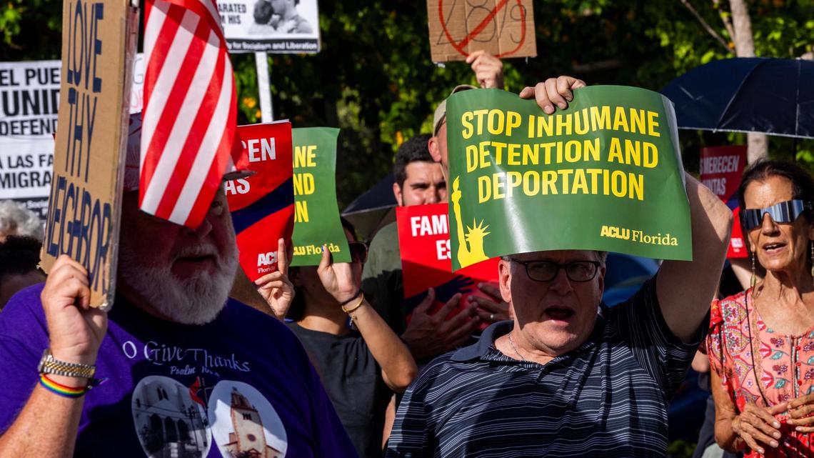 Demonstrators wave signs that read “STOP INHUMANE DETENTION AND DEPORTATION” during a press conference hosted by ACLU Florida, Florida Rising, The Florida Immigrant Coalition and Family Action Network Movement on Tuesday, June 17, 2025, in Miami.