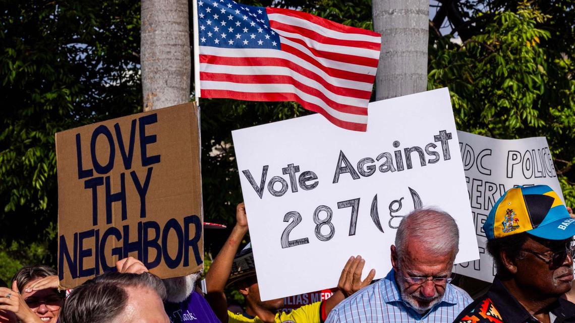 Demonstrators hold signs that read “LOVE THY NEIGHBOR” and “VOTE AGAINST 287(g)” during a press conference hosted by ACLU Florida, Florida Rising, The Florida Immigrant Coalition and Family Action Network Movement on Tuesday, June 17, 2025, in Miami.