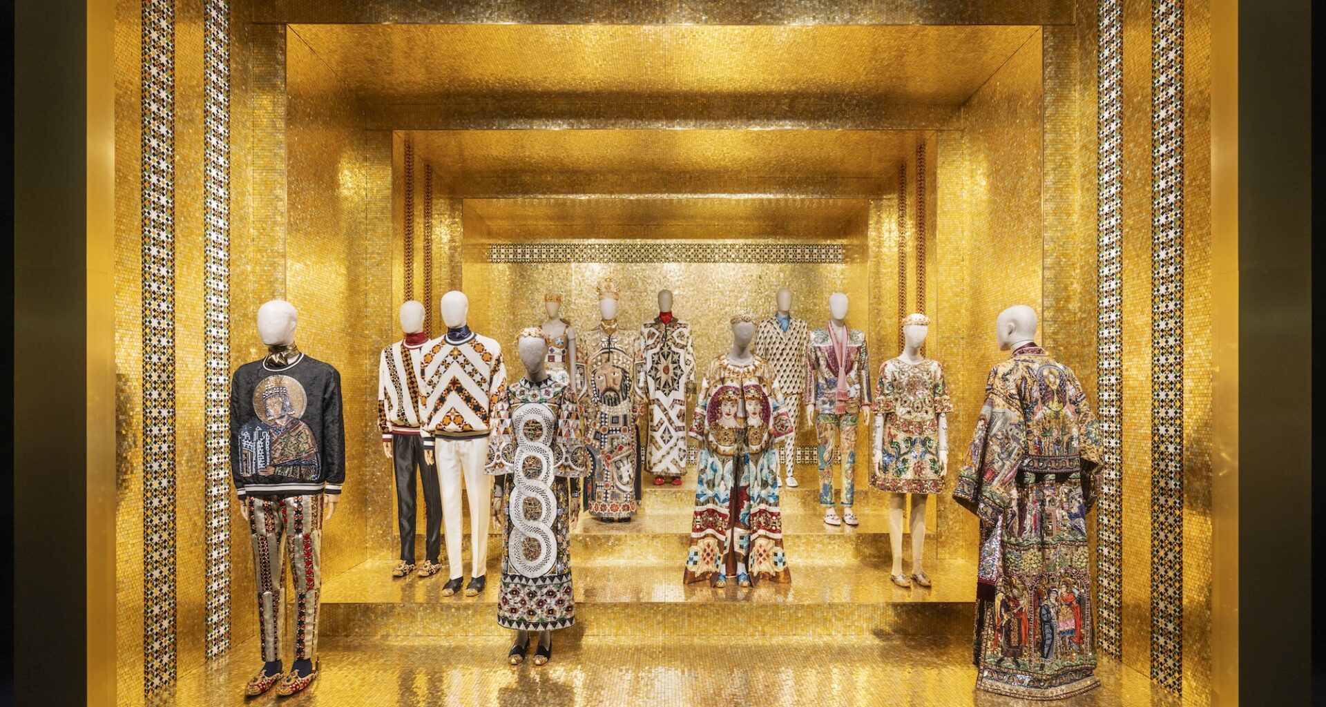 photo of outfits on mannequins inside a room with gold walls and flooring