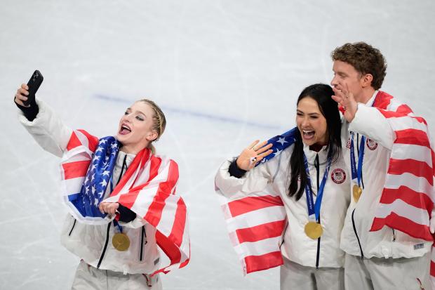 From left, Amber Glenn and ice dance team Madison Chock and Evan Bates celebrate winning the gold medal after the figure skating team event at the 2026 Winter Olympics, in Milan, Italy, Sunday, Feb. 8, 2026. (AP Photo/Natacha Pisarenko)