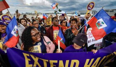 A photo shows a large crowd of protesters holding Haitian flags and signs that read, "Extend Haitian TPS!"