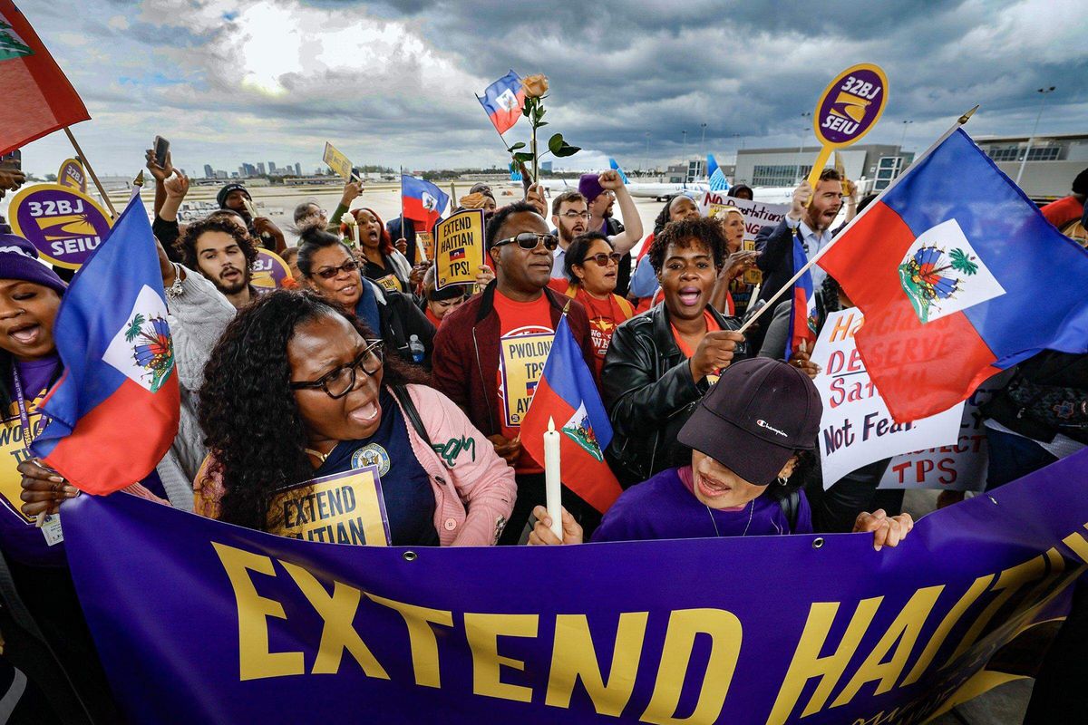 A photo shows a large crowd of protesters holding Haitian flags and signs that read, "Extend Haitian TPS!"