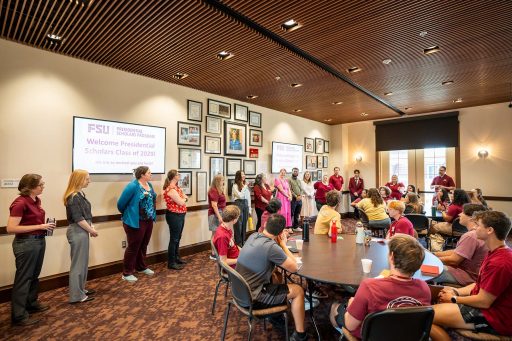 The Class of 2029 Presidential Scholars cohort sits together at tables while hearing from staff who will assist them in their academic journeys.