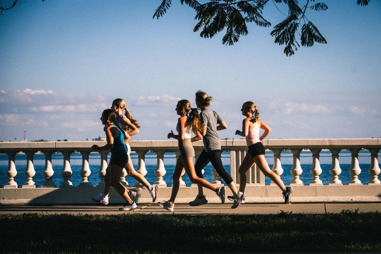 Plant High School cross country coach Katie Nelson running with student-athletes along the iconic balustrade of Bayshore Boulevard in Tampa, Florida.