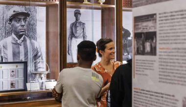 Onlookers walk through the traveling exhibition of The Heart of the Turf: Racing’s Black Pioneers. The exhibition showcases historical imagery, items, and information that explores African American history in Thoroughbred racing and examines how generations of Black professionals shaped the United States racing industry while facing systemic racism and exclusion. (Photo: ©Keeneland)